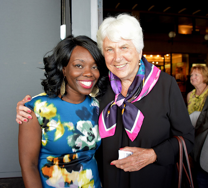 Two ladies smiling and posing for a photo