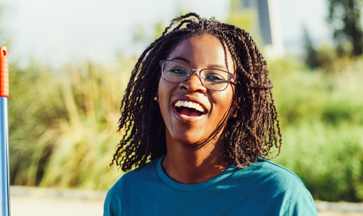 Woman holding a rake smiling at the camera