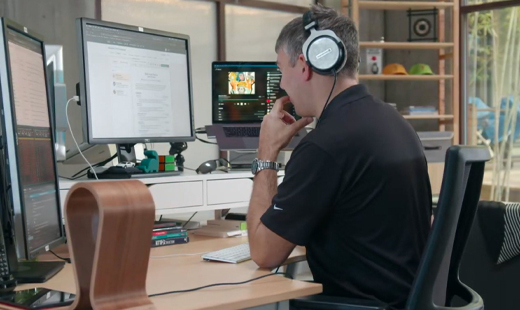 Man working on a computer with headphones on