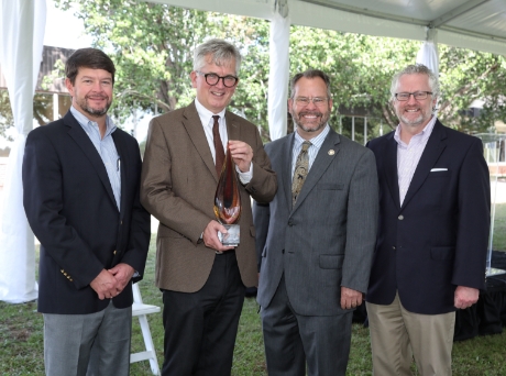 Group of men holding an award smiling