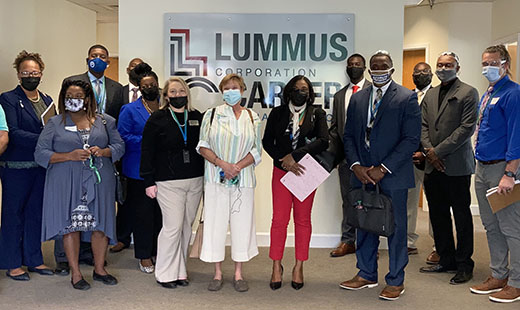 Group photo with people dressed up in front of Lummus sign