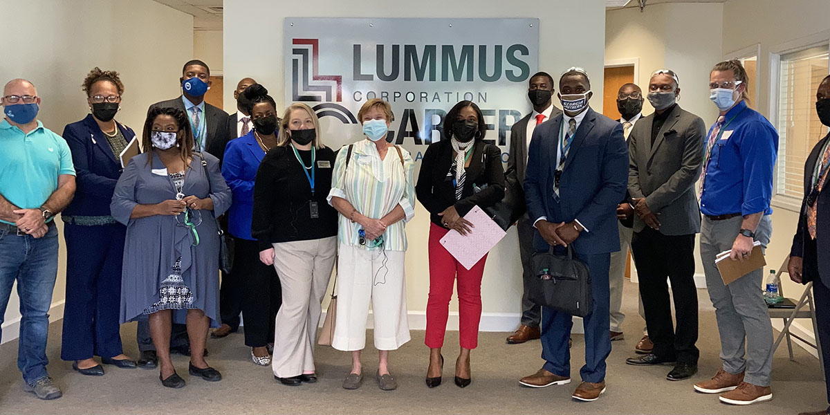 Group photo people dressed up in front of Lummus sign